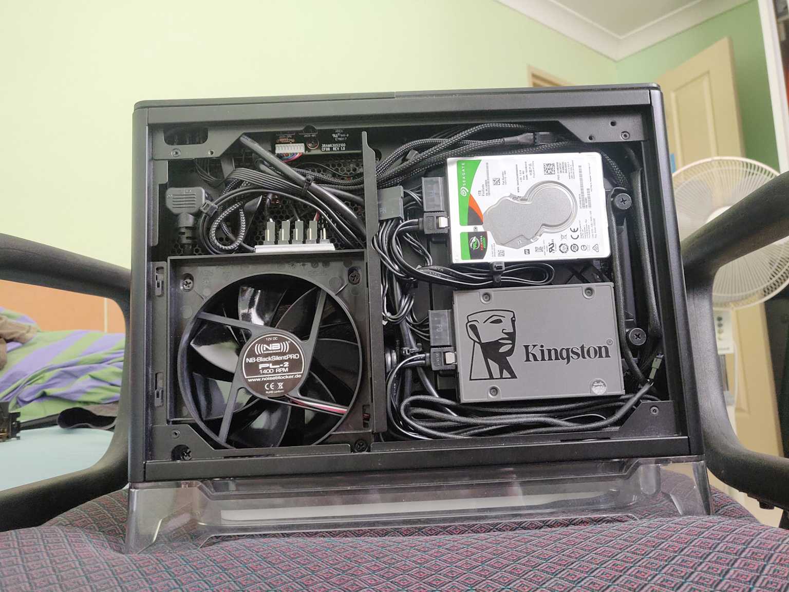 Gestion soignée des câbles à l'intérieur d'un boîtier Mini-ITX montrant des câbles organisés, un ventilateur de refroidissement et des disques de stockage pour un flux d'air optimal et une configuration propre reddit